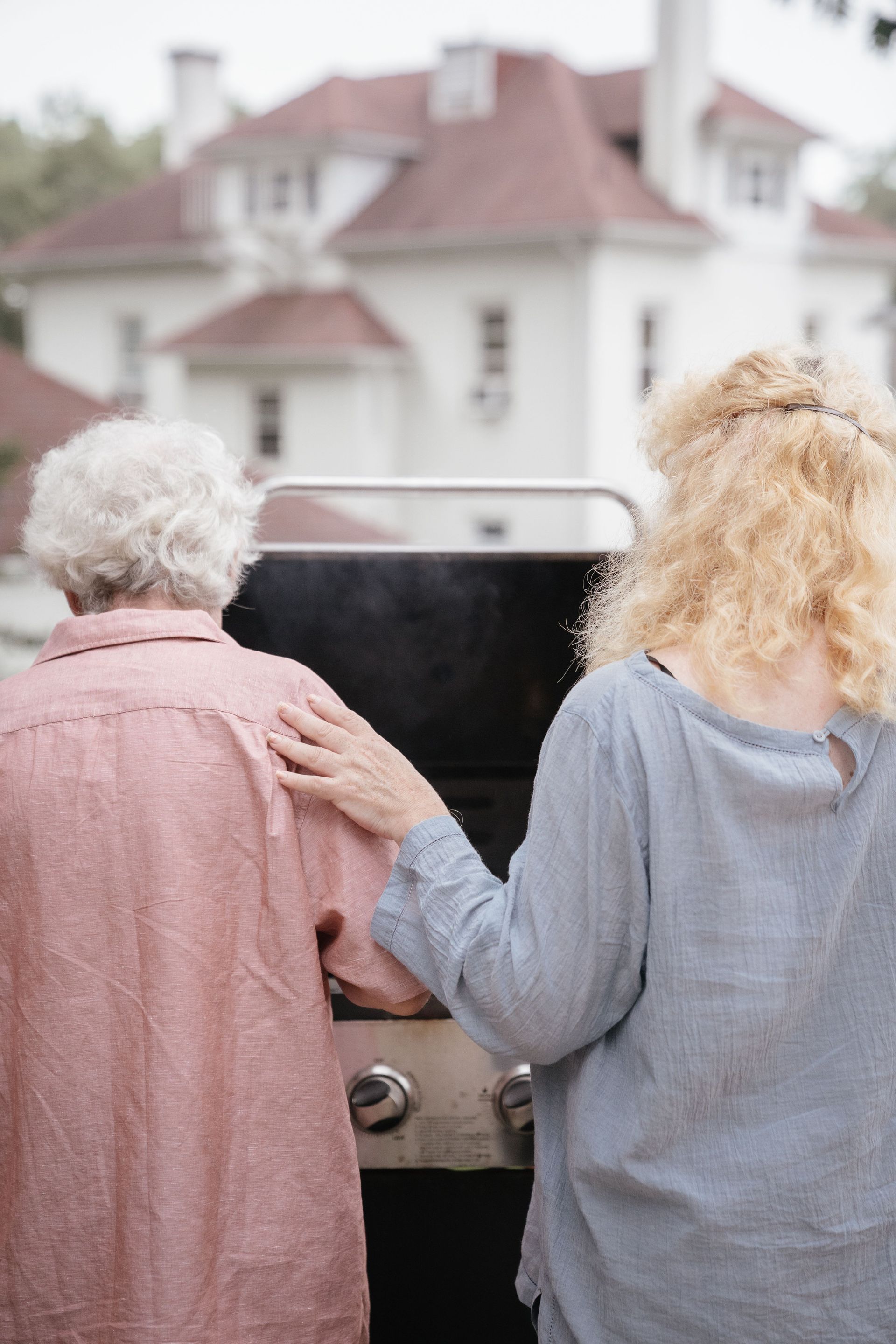 Elderly couple bonding over outdoor barbecue, showcasing companionship and leisure.